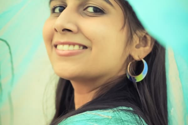 A smiling young woman under a soft turquoise veil
